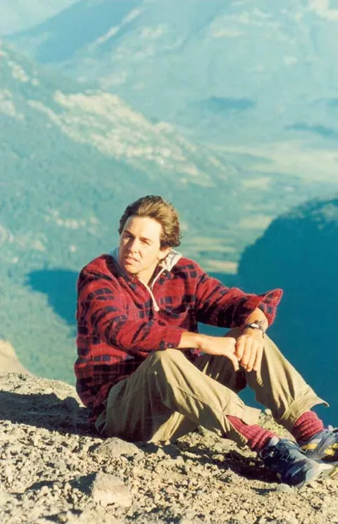 Guillermo seated high on the mountain, in a checked shirt