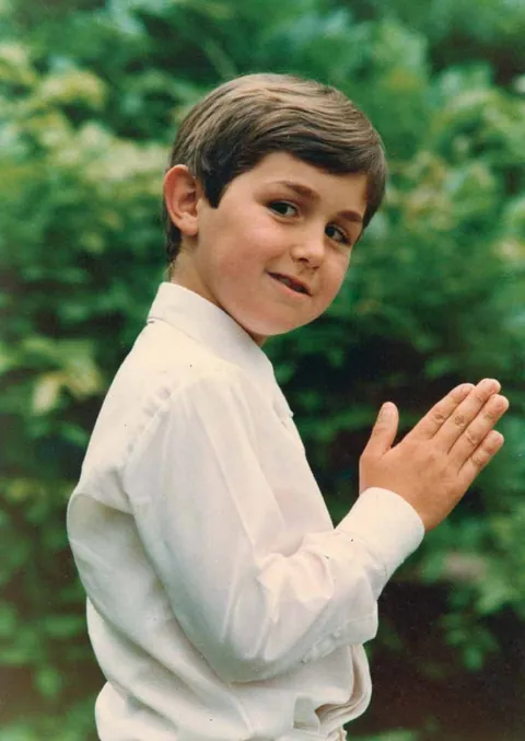 Guillermo as a boy at his first communion, hands joined