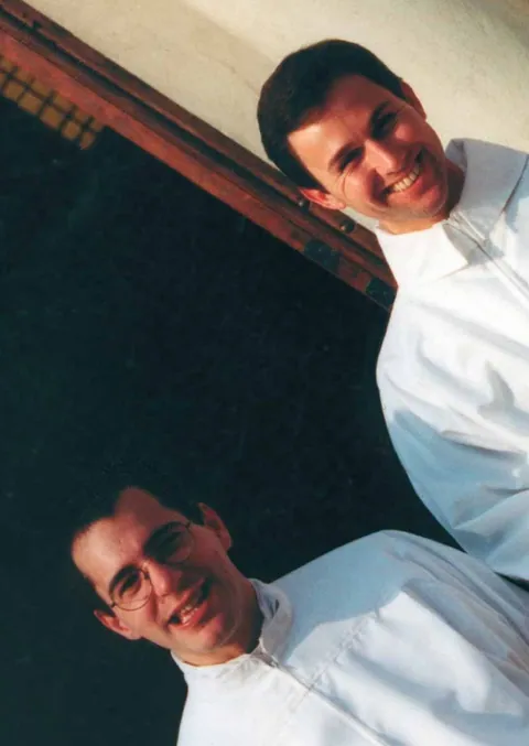 Guillermo in an alb, smiling, with a seminary companion